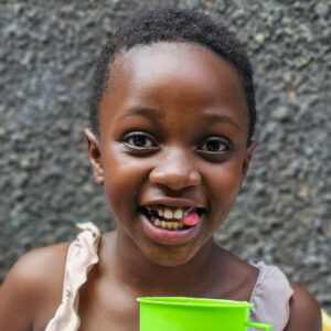 smiling little girl holding a cup